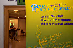 Ein gelbes Banner mit der Aufschrift "Smartphone Entdecken – Lernen Sie alles über Ihr Smartphone mit Ihrem Smartphone".